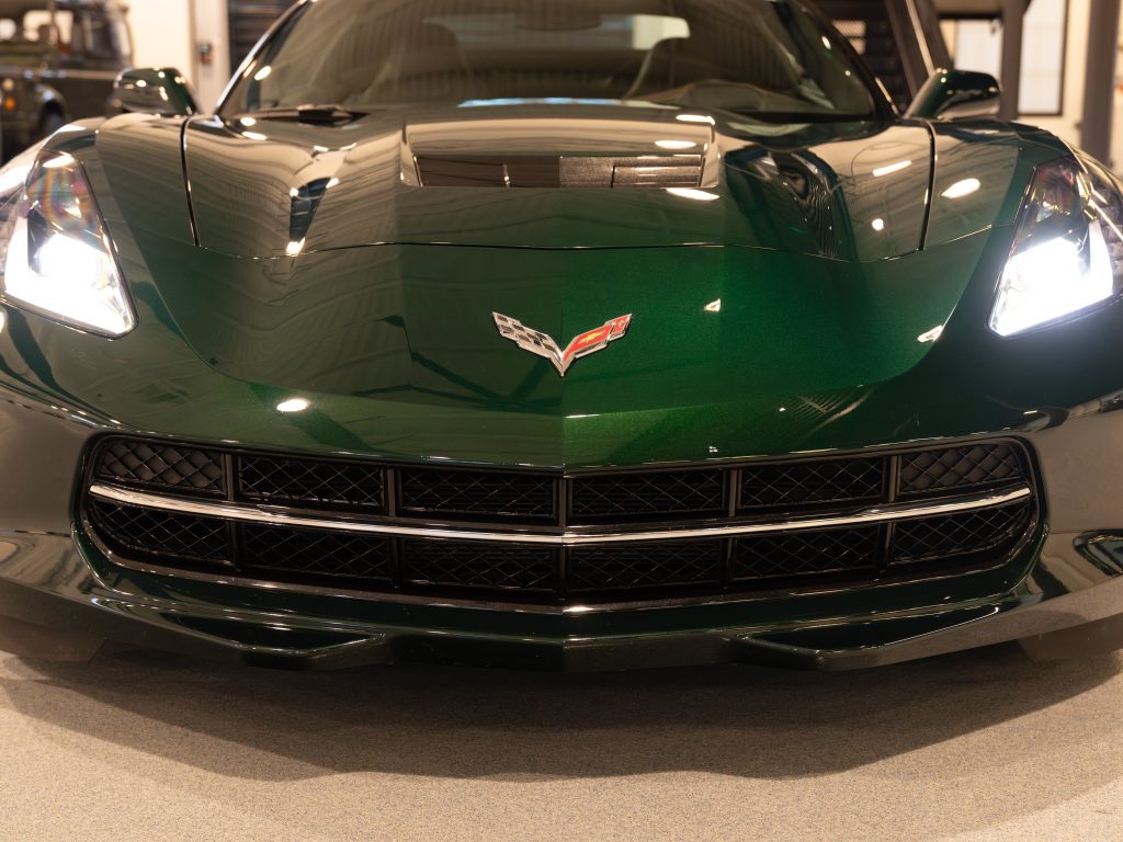 Green sports car front view showcasing the grille and emblem. - Monarch Showroom