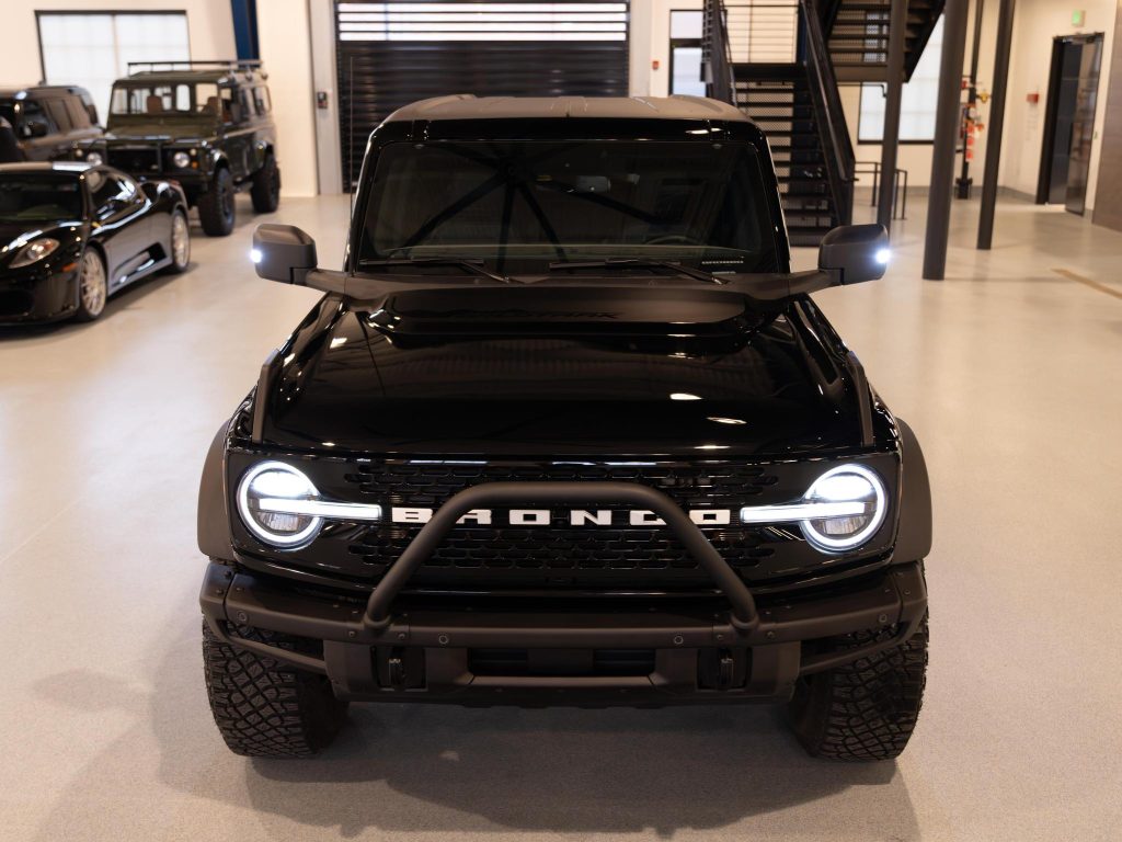 Black ford bronco parked indoors with headlights on. - Monarch Showroom