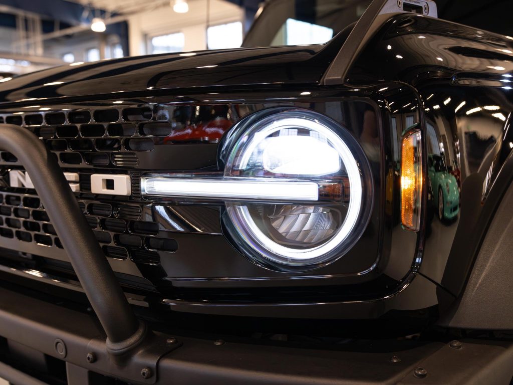 Close-up view of a modern vehicle's headlight and grille design. - Monarch Showroom