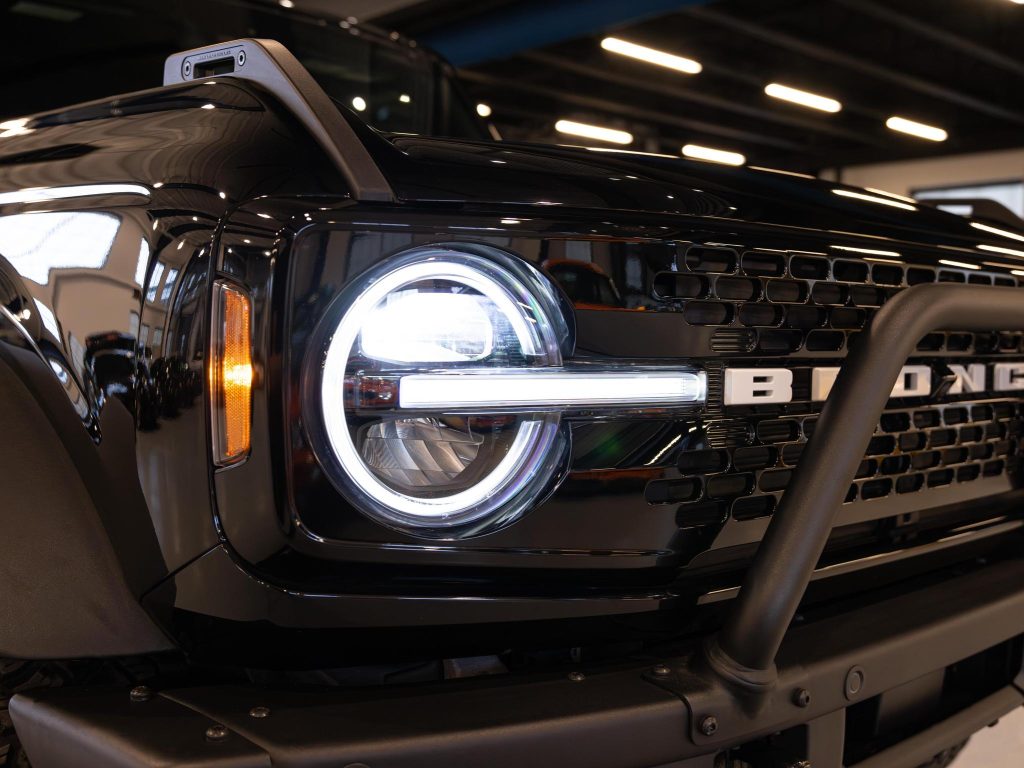 Close-up of a ford bronco's front grille and headlight. - Monarch Showroom