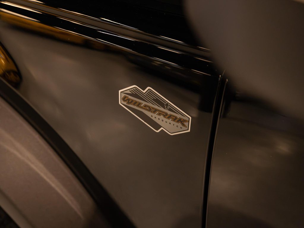 Close-up of a vehicle's black panel with a "wildtrak" badge. - Monarch Showroom