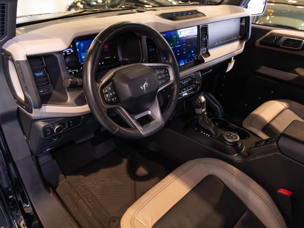 Interior view of a modern vehicle showcasing the steering wheel, dashboard, and center console. - Monarch Showroom