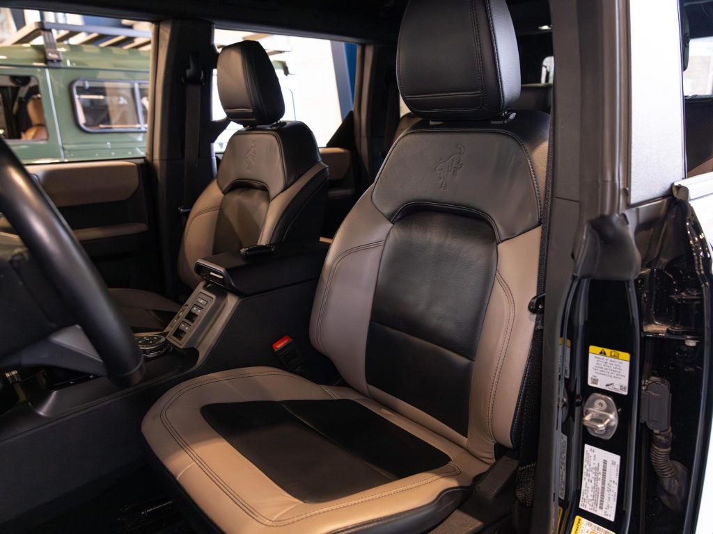 Luxury car interior with leather seats and center console visible from the driver's side door. - Monarch Showroom