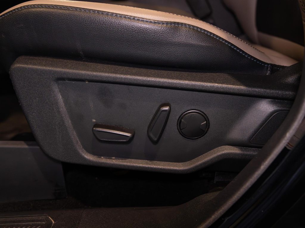 Car seat adjustment controls on the side of a vehicle seat. - Monarch Showroom