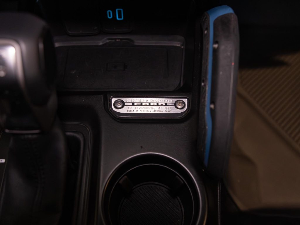 Car interior showing gear shift, cup holder, and usb port with charging cable. - Monarch Showroom