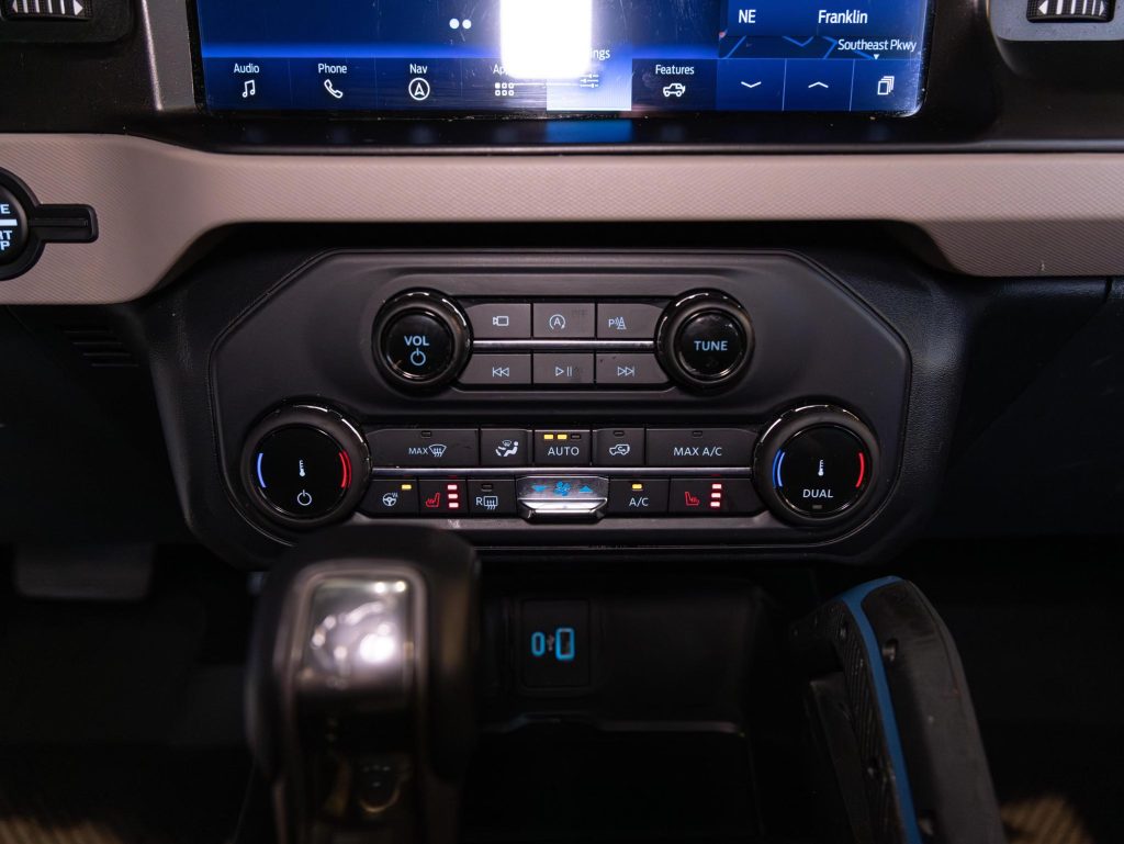 Climate control interface and entertainment system controls on a vehicle's center console. - Monarch Showroom