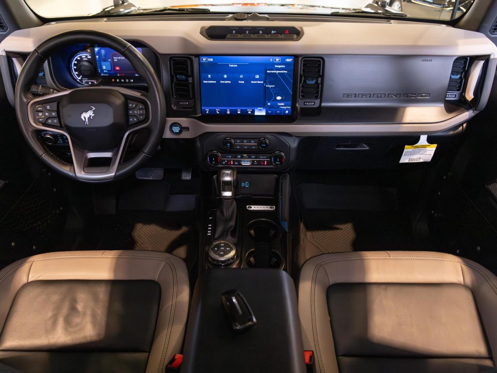 Interior view of a modern vehicle showcasing the dashboard, infotainment system, and front seats. - Monarch Showroom