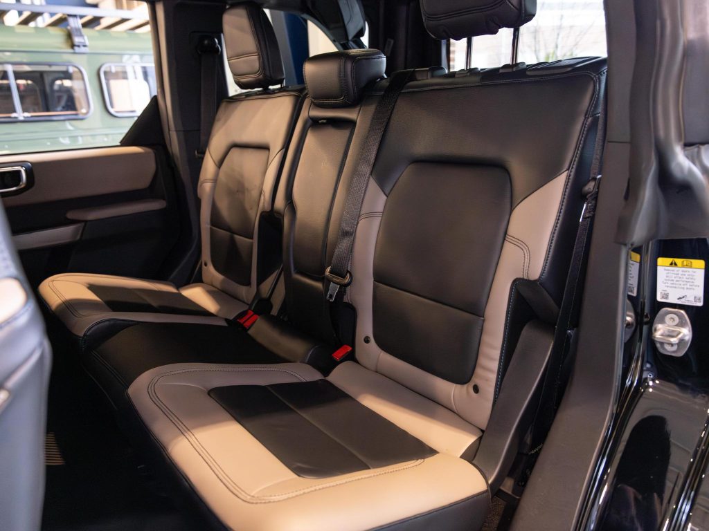 Interior view of a vehicle showing leather seats with a two-tone color scheme. - Monarch Showroom