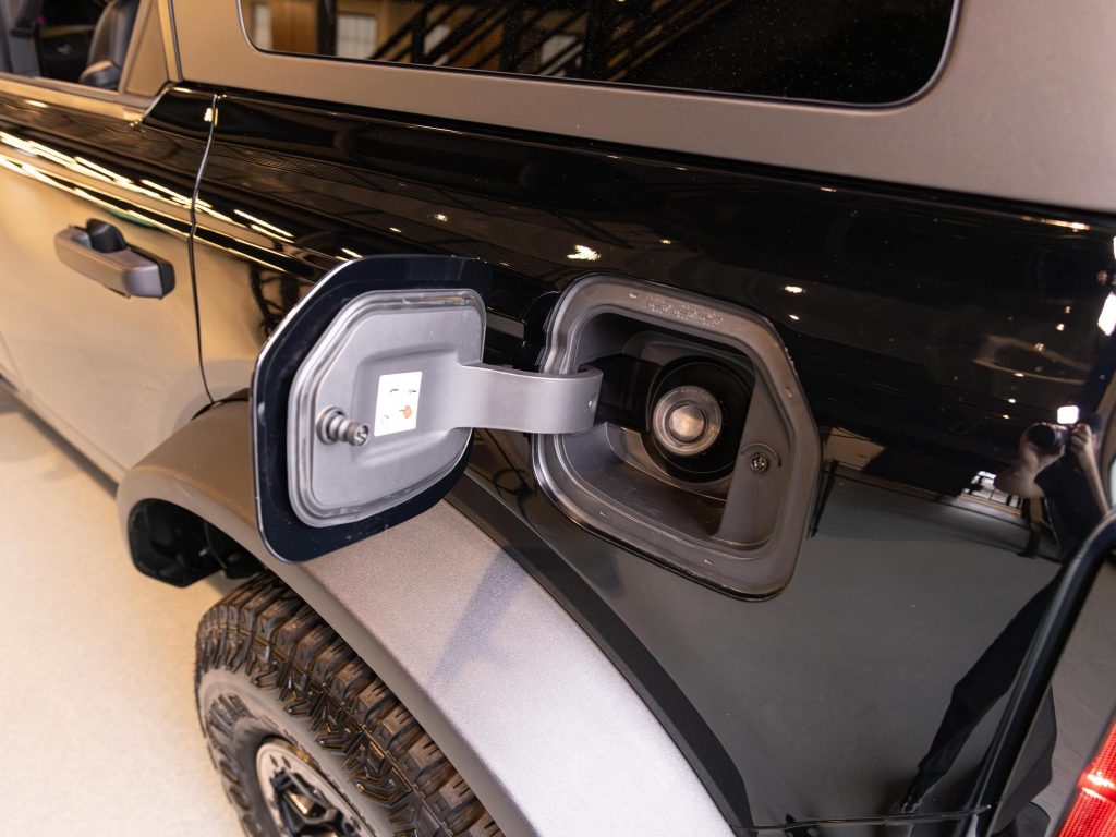 A vehicle's fuel cap is open, revealing the fuel filler neck. - Monarch Showroom