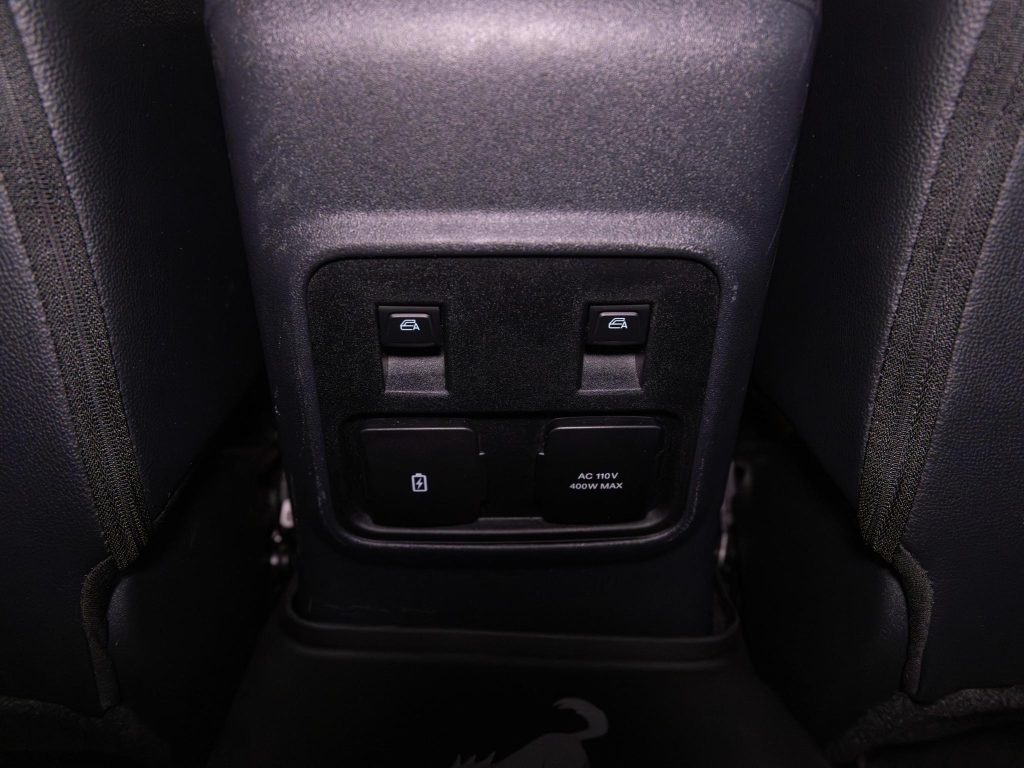 Rear center console in a car with window control buttons and usb charging ports. - Monarch Showroom