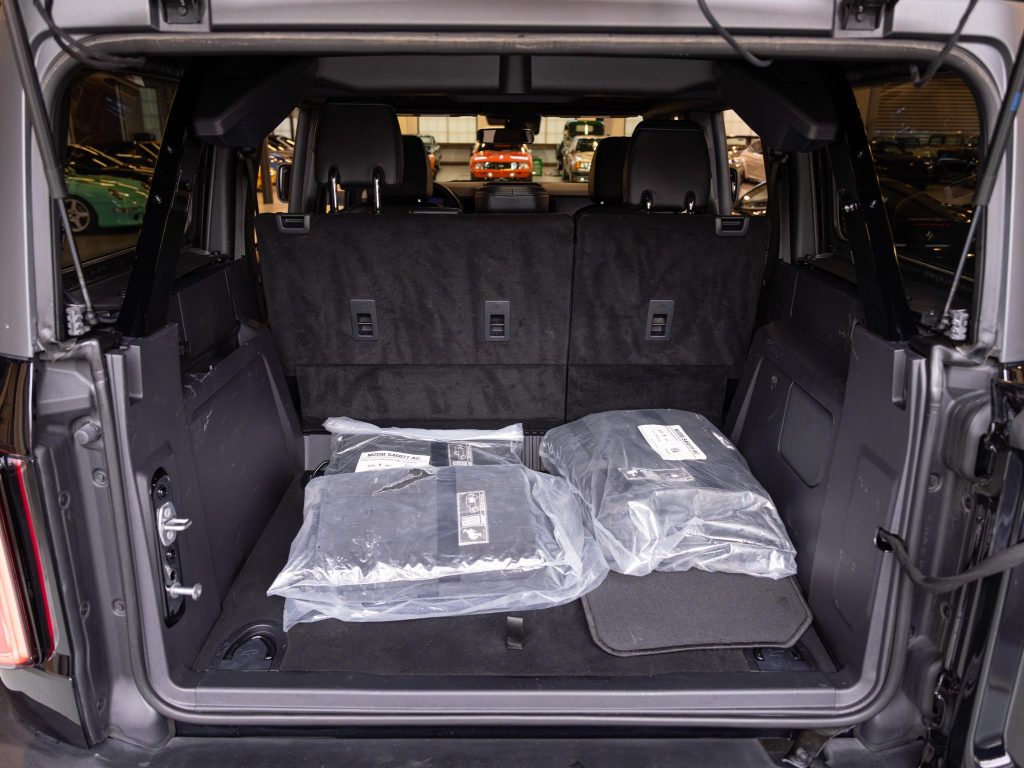 Cargo area of an suv with folded seats and items packed in protective packaging. - Monarch Showroom