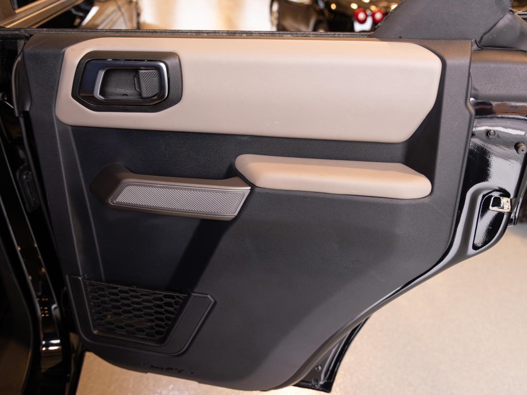 Interior view of a car door with a handle, speaker, and storage compartment. - Monarch Showroom