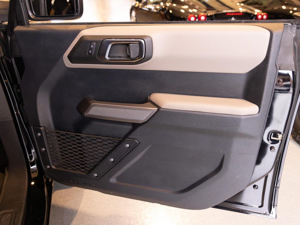 Interior door panel of a car with controls and storage compartments. - Monarch Showroom