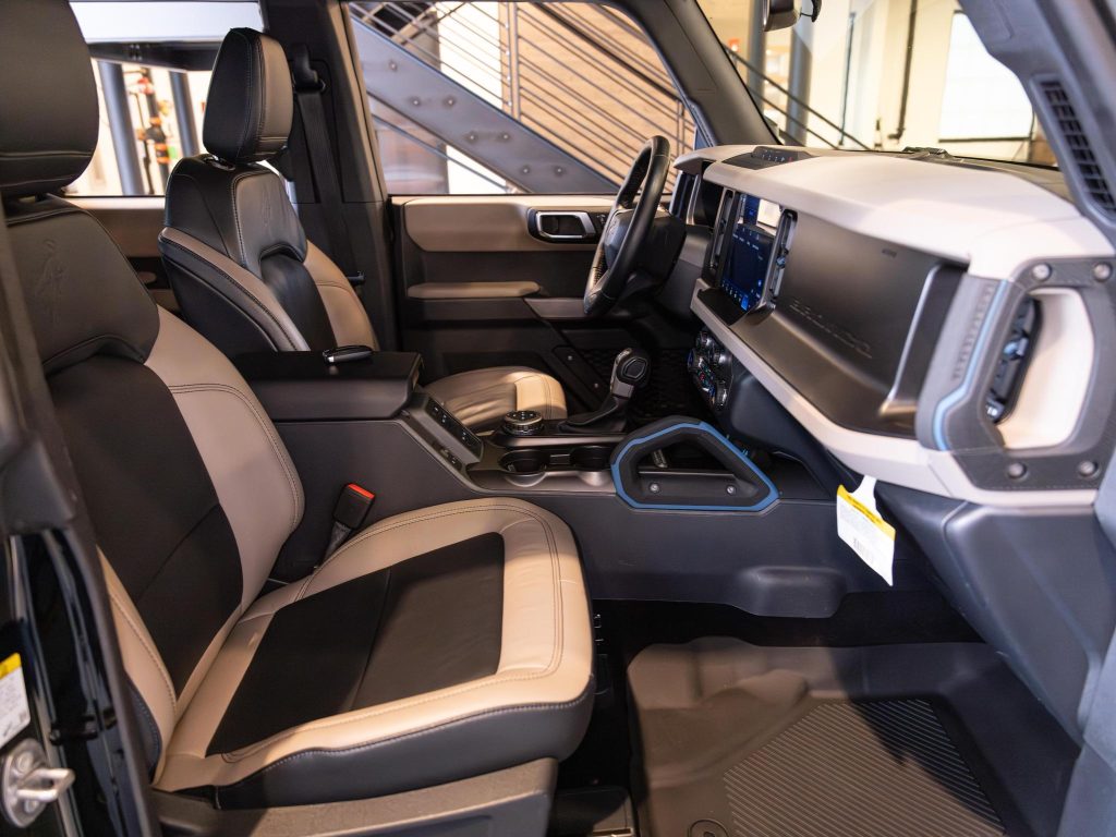 Interior view of a modern vehicle showcasing the front seats, dashboard, center console, and infotainment system. - Monarch Showroom