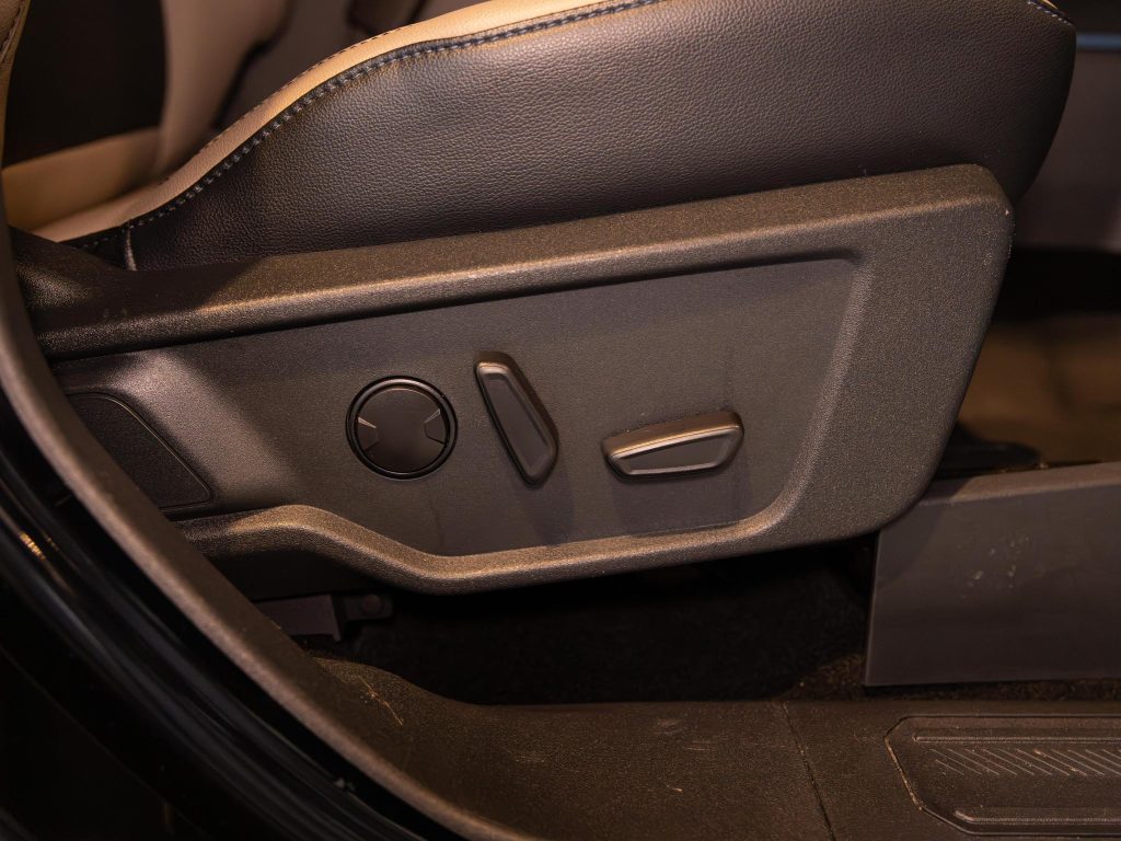 Car's side door interior with control buttons for windows and side mirrors. - Monarch Showroom