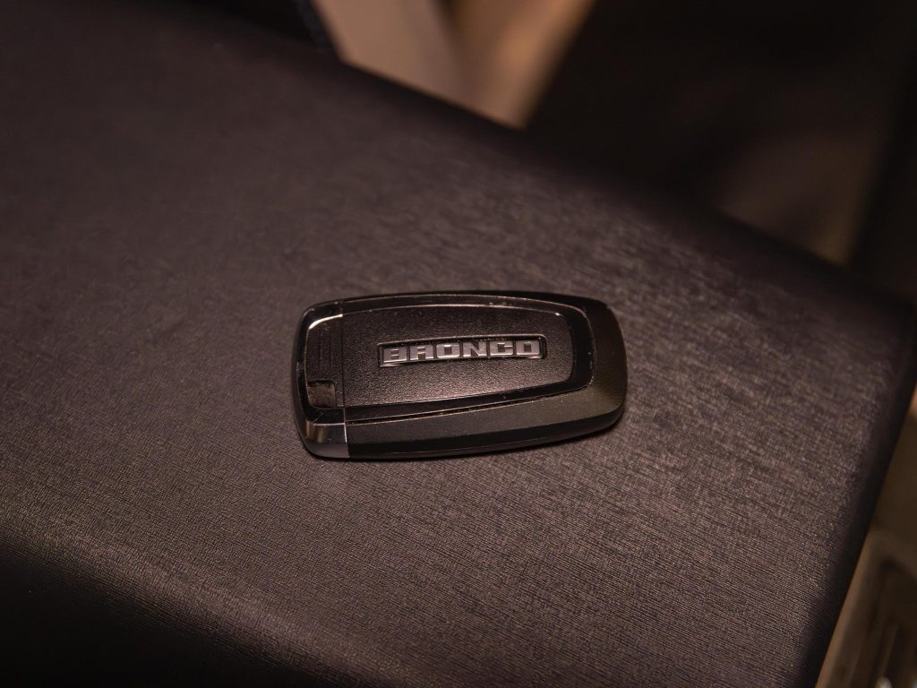 Black vehicle key fob with "bronco" text on a dark surface. - Monarch Showroom