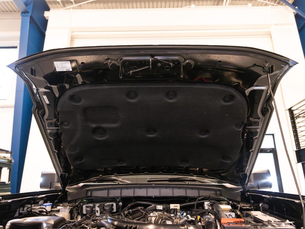 Hood of a car open revealing the engine compartment in a workshop setting. - Monarch Showroom