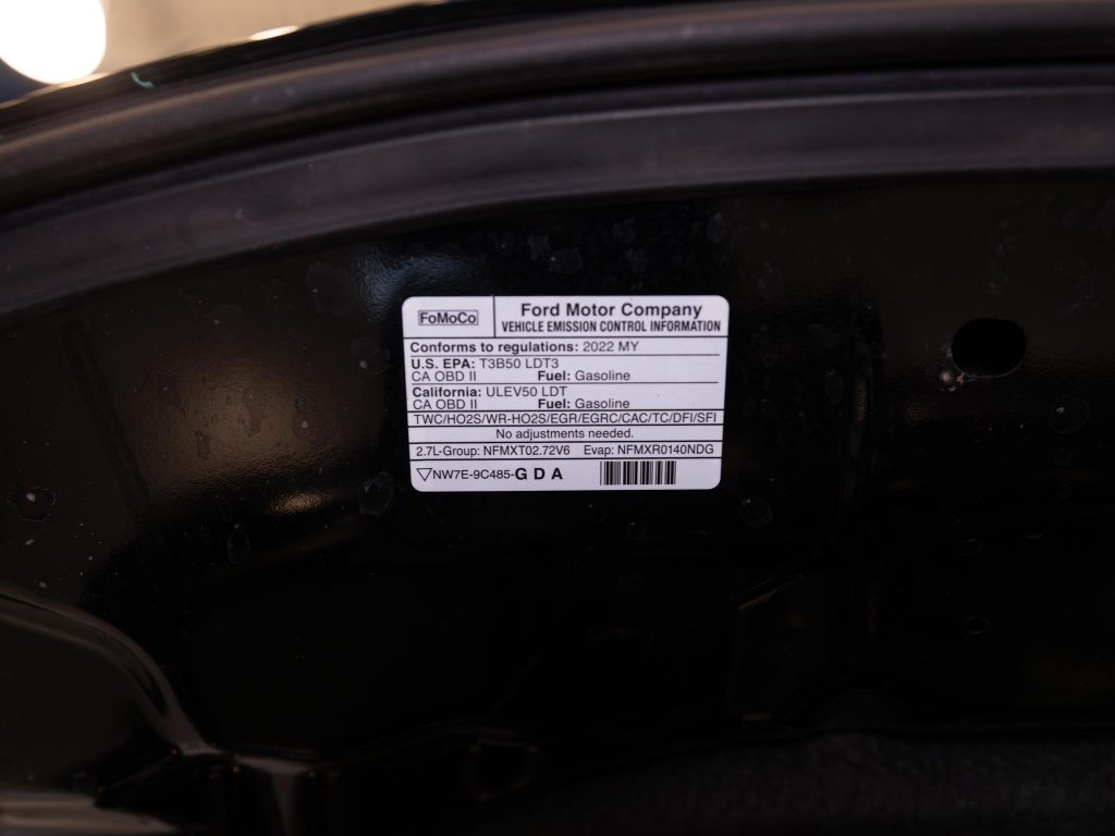 Vehicle emission control information label from ford motor company affixed inside a car's engine compartment. - Monarch Showroom