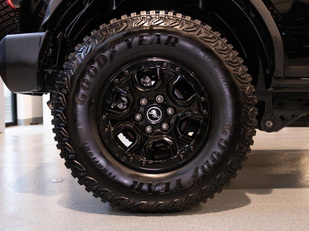 Close-up view of a black off-road vehicle tire with detailed tread pattern and branded with "goodyear. - Monarch Showroom