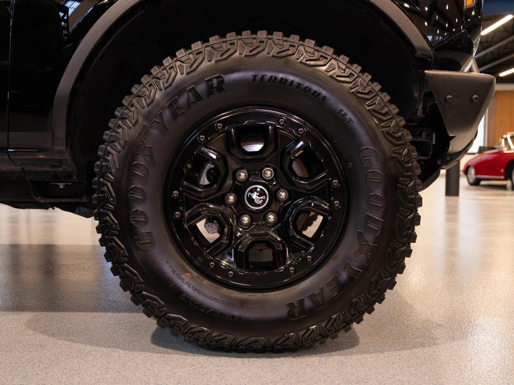 Close-up view of a black off-road tire on a vehicle with the "goodyear wrangler" brand visible. - Monarch Showroom