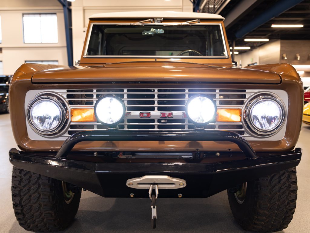 Front view of a vintage ford bronco with round headlights and a metallic grille. - Monarch Showroom