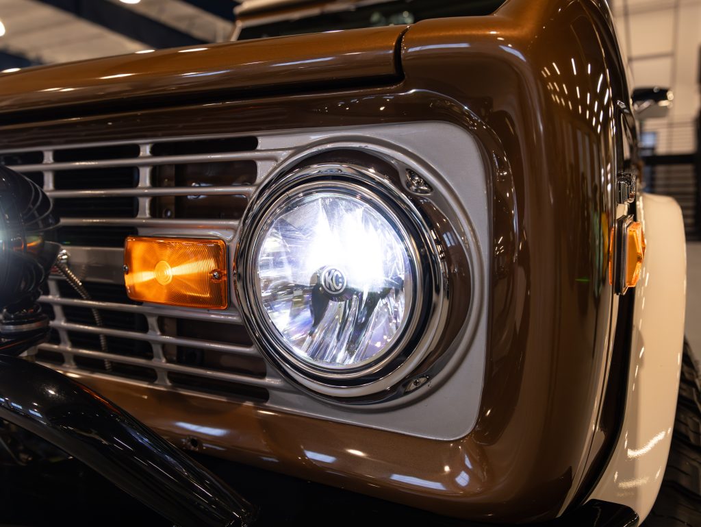 Close-up of a vintage car's front headlight and grille. - Monarch Showroom