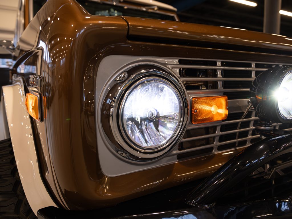 Close-up view of a vintage car's headlight, grille, and turn signal. - Monarch Showroom