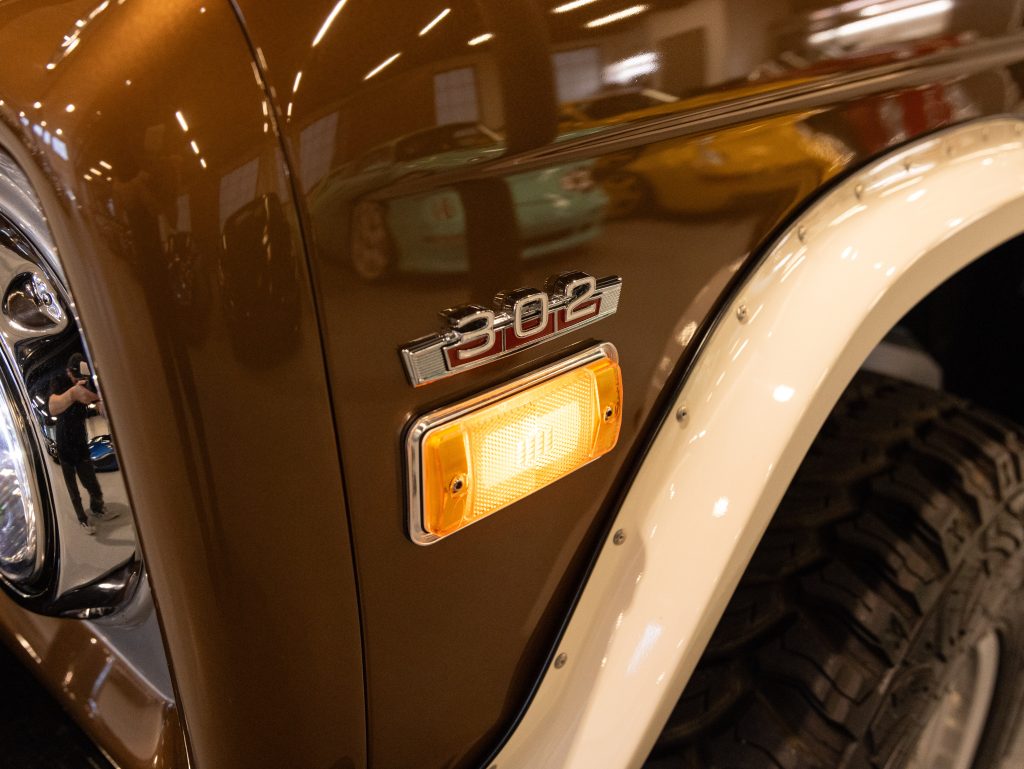Close-up of a vintage car's fender displaying the "308" emblem and side indicator. - Monarch Showroom