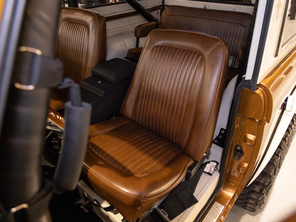 Interior view of a vehicle showing brown leather seats and a door open. - Monarch Showroom