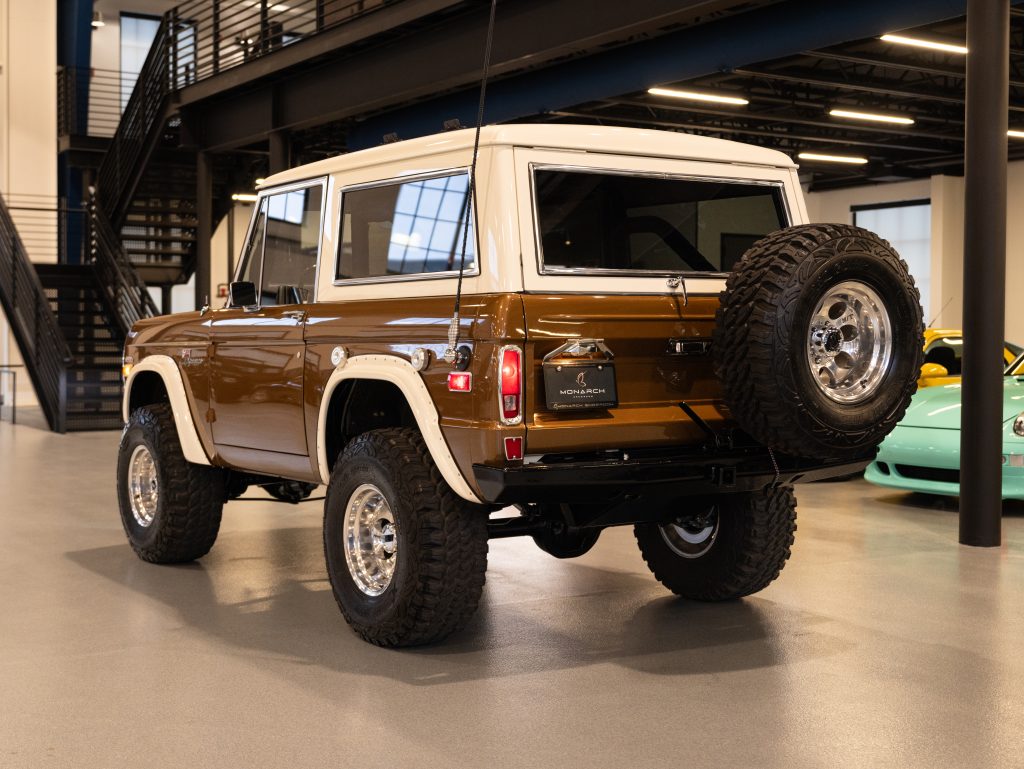Vintage brown suv with large tires parked inside a modern garage. - Monarch Showroom