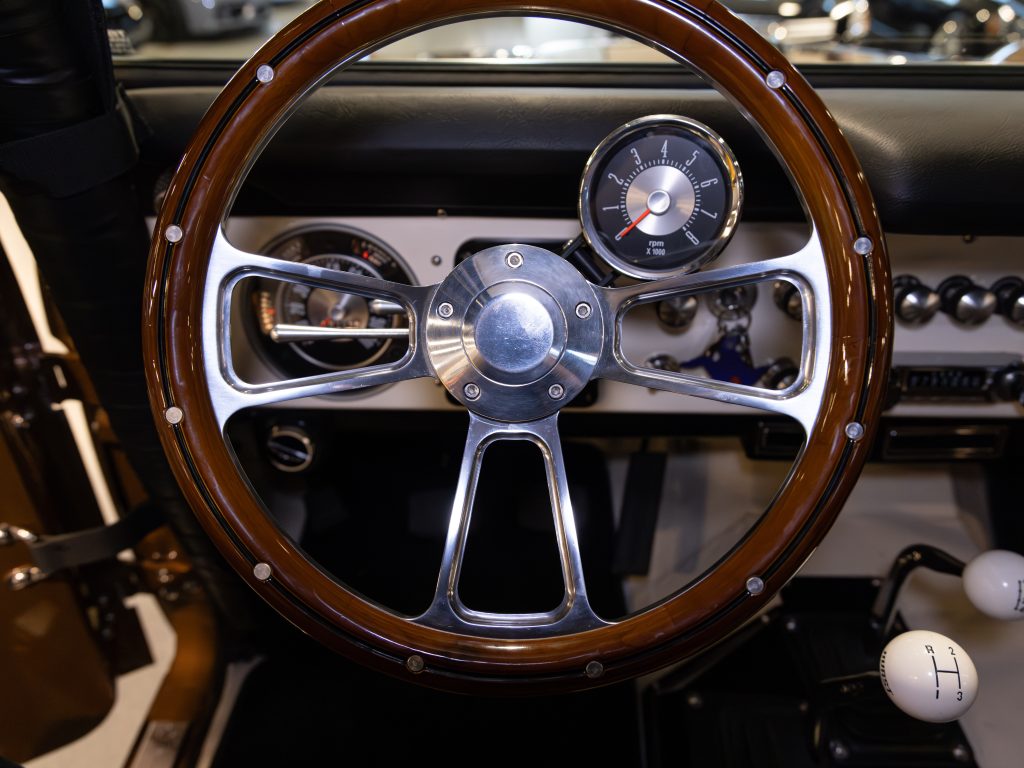 Close-up view of a classic car's steering wheel and dashboard. - Monarch Showroom