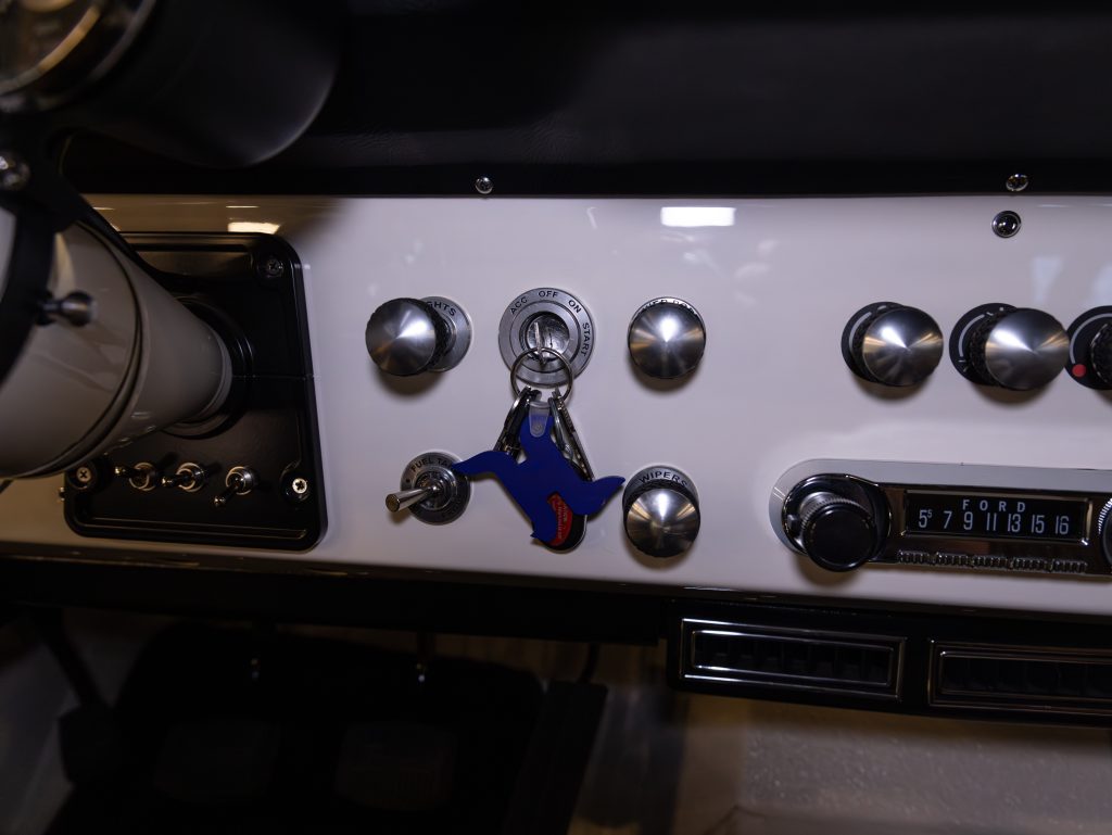 Classic car dashboard with vintage ignition switch and chrome knobs. - Monarch Showroom