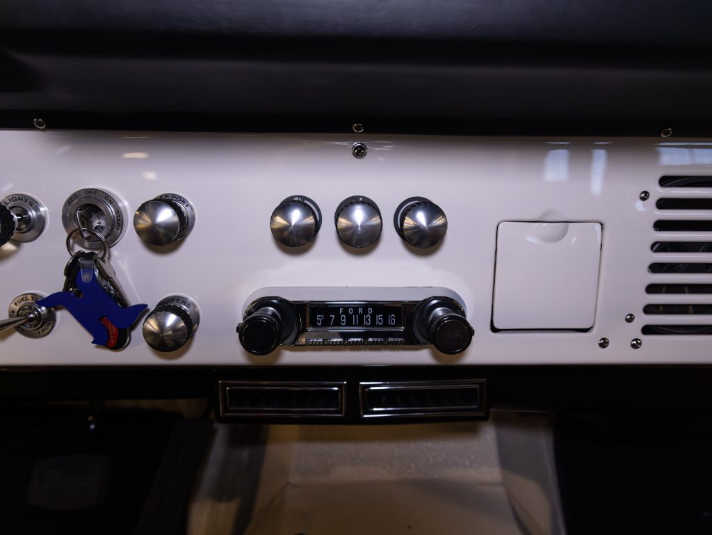 Dashboard of a vintage car showing odometer, radio, and control knobs. - Monarch Showroom