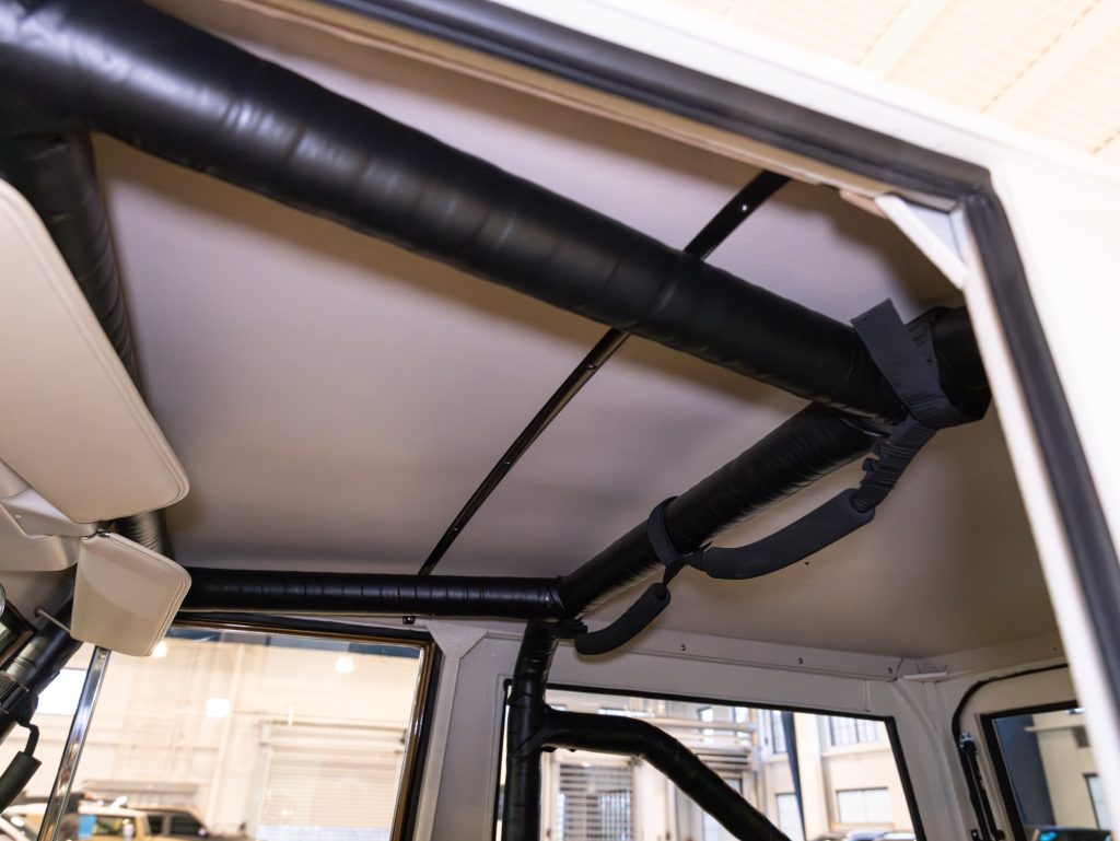 Interior view of a vehicle's roll cage with padded bars. - Monarch Showroom