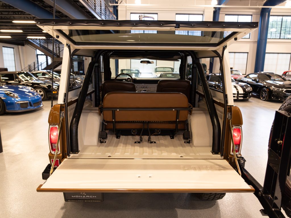 Rear view of an open cargo area of a luxurious suv with leather seats and the tailgate down. - Monarch Showroom