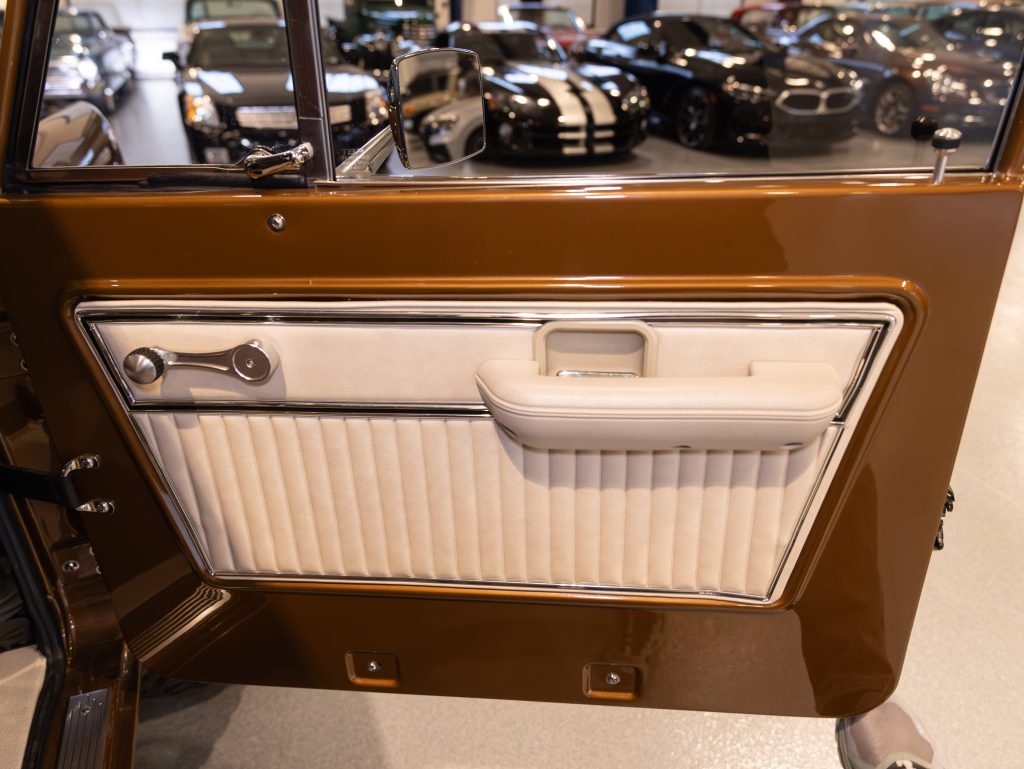 Close-up view of a classic car's door interior featuring brown and white panels with chrome handles. - Monarch Showroom