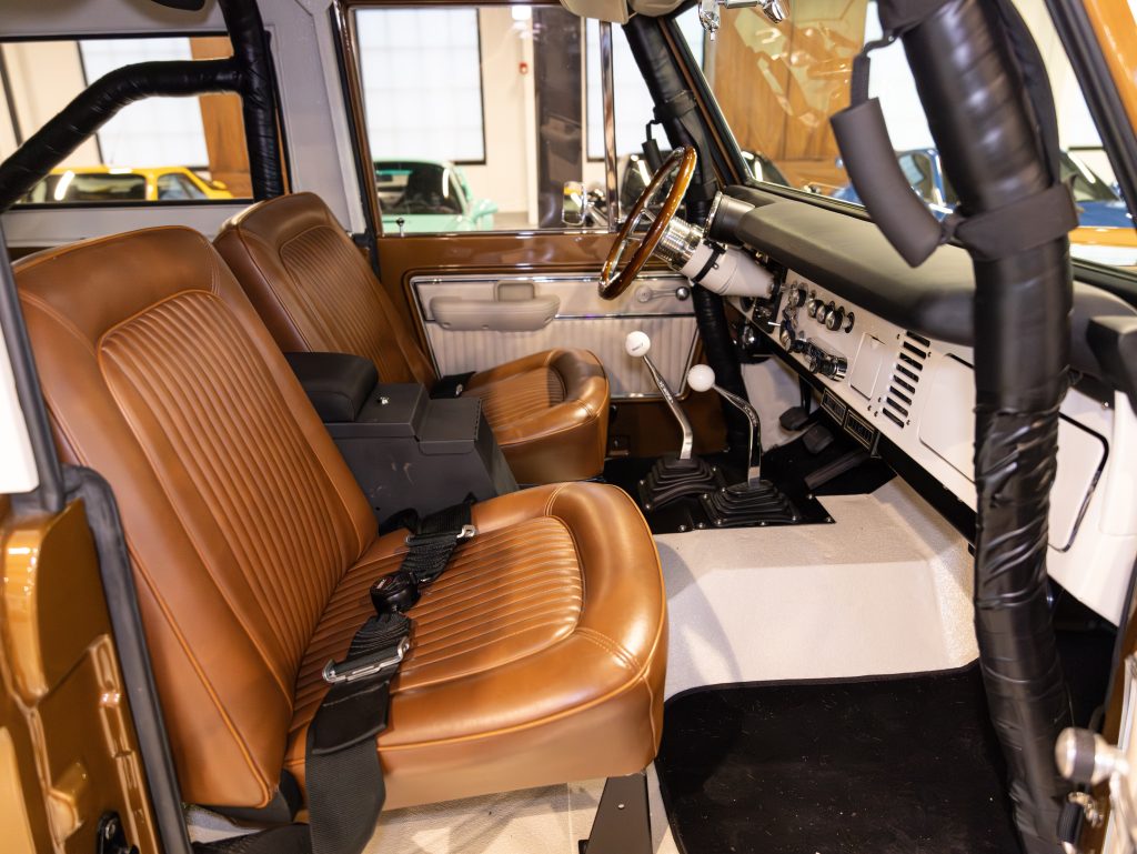 Interior view of a classic car showcasing brown leather seats and vintage dashboard. - Monarch Showroom