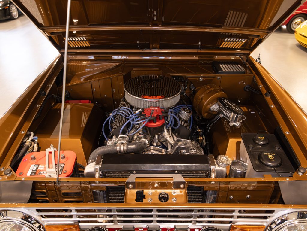 An immaculately detailed classic car engine bay with visible components and wiring. - Monarch Showroom