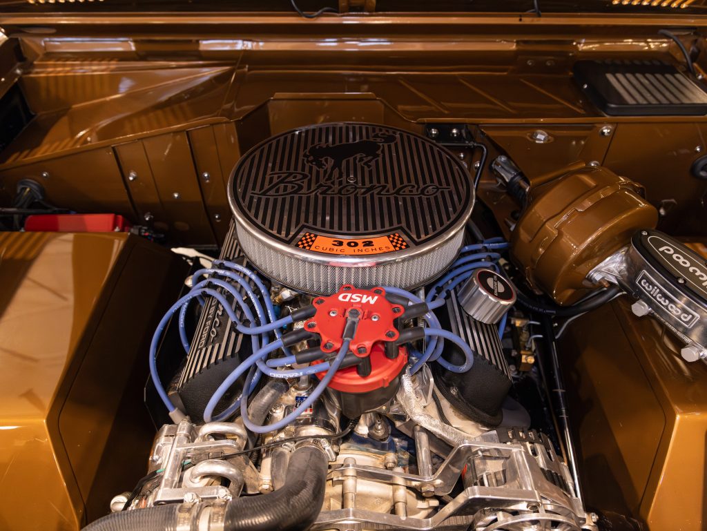 V8 engine with aftermarket components in a classic car's engine bay. - Monarch Showroom