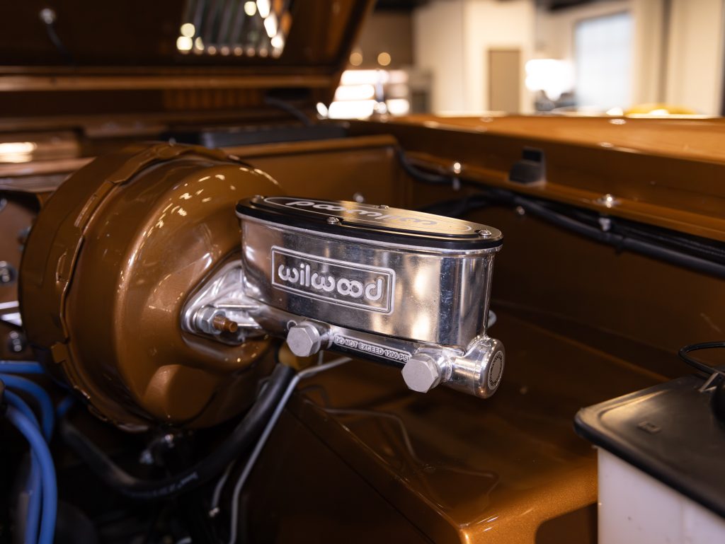 Close-up of a polished brake fluid reservoir in a classic car engine bay. - Monarch Showroom