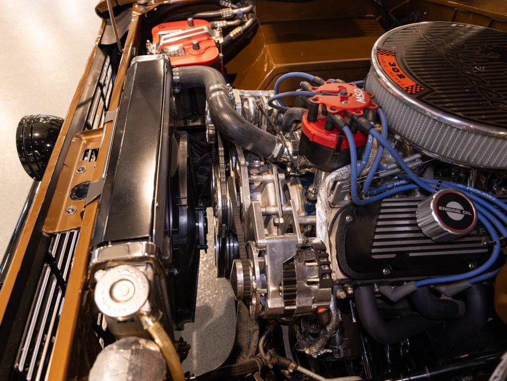 Close-up of a classic car's meticulously maintained engine bay with chrome detailing. - Monarch Showroom