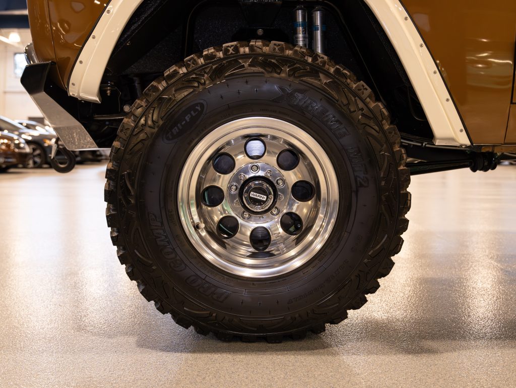 Close-up of a vehicle's off-road tire and polished alloy wheel. - Monarch Showroom