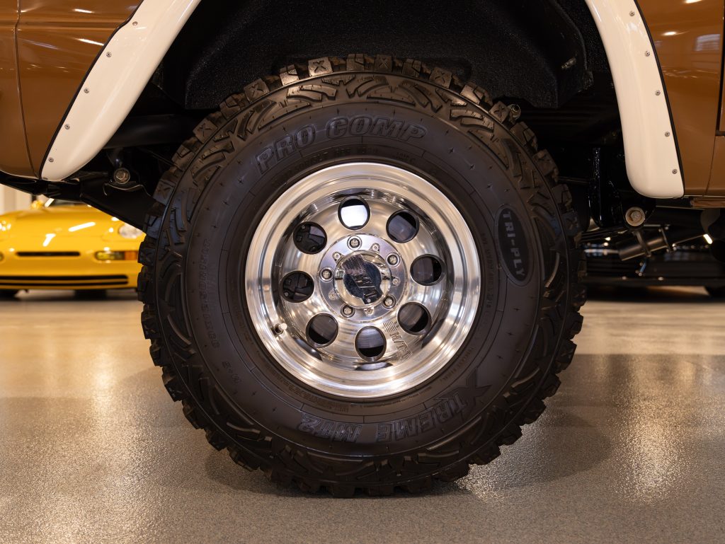 Off-road vehicle wheel with pro comp tire on a polished alloy rim. - Monarch Showroom