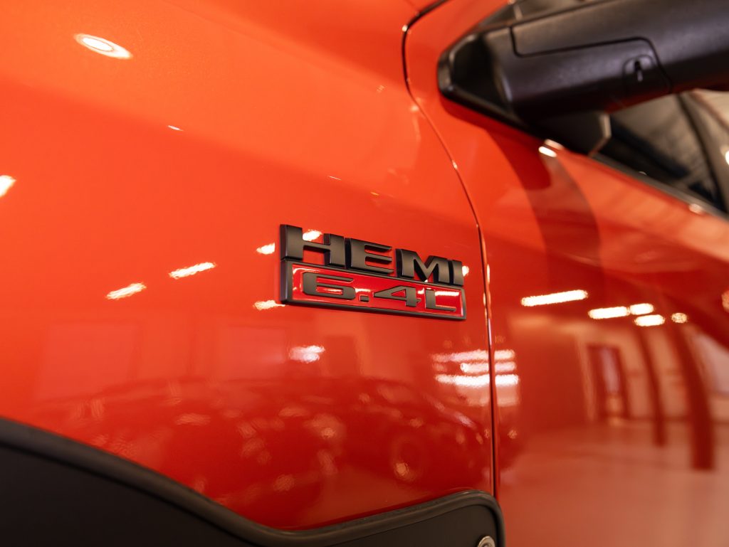 Close-up of a red car with a "hemi 6.4l" badge. - Monarch Showroom