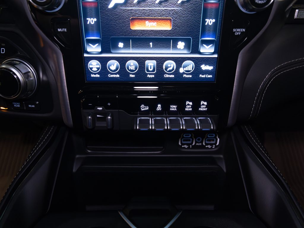 Interior view of a car's center console featuring a touchscreen infotainment system and climate controls. - Monarch Showroom