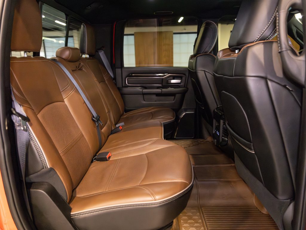 Luxury vehicle interior showcasing brown leather seats with ample legroom and modern design elements. - Monarch Showroom