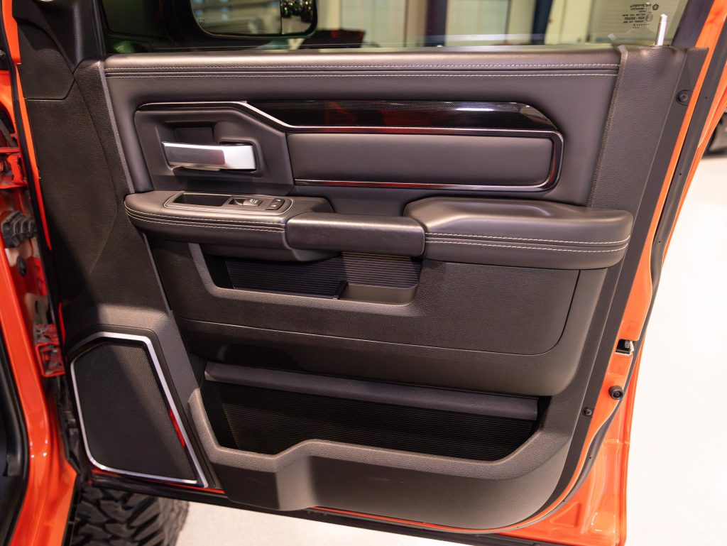Interior door panel of a modern vehicle with controls and storage compartments. - Monarch Showroom