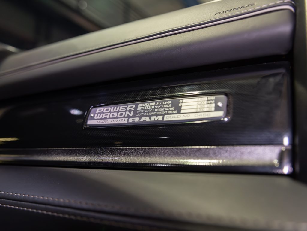 Close-up view of a vehicle's identification badge displaying "power wagon" and specific model details on a dashboard_trim. - Monarch Showroom