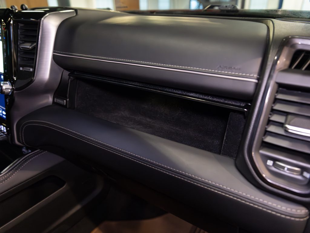 Interior view of a car's dashboard featuring a leather finish with contrasting stitching. - Monarch Showroom
