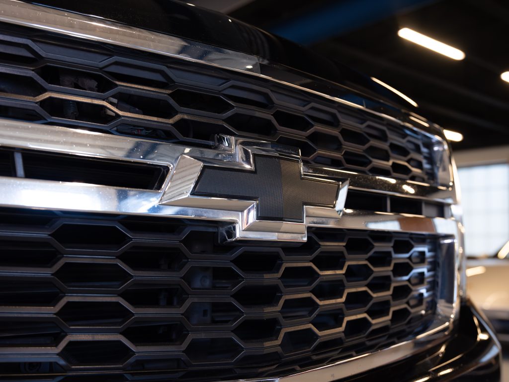 Close-up of a Chevrolet vehicle grille featuring the silver Chevrolet logo on a black honeycomb-patterned background. - Monarch Showroom